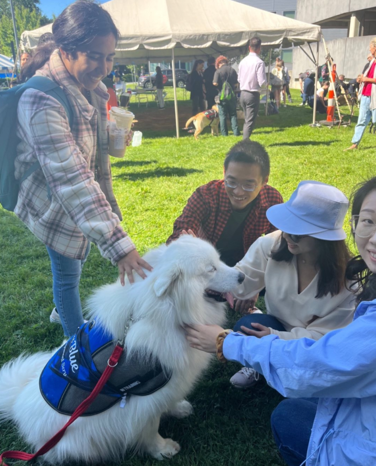 A group of people petting Laika Blue at Yale Health event.